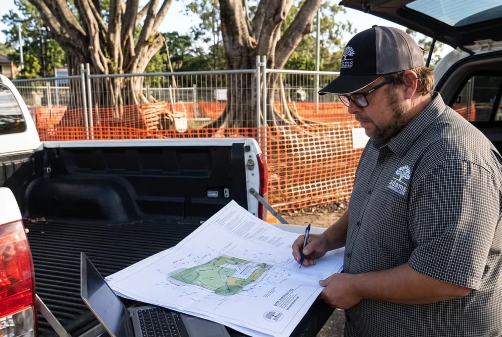 Adam De Regt recording findings against site plans on a ute tailgate